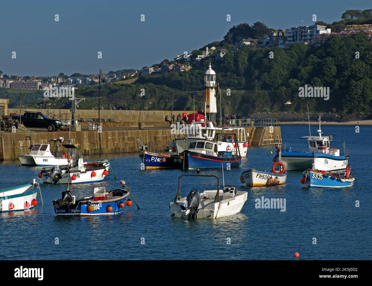 Il porto di St Ives, Cornovaglia, Inghilterra, Regno Unito, barche ormeggiate e faro Foto Stock