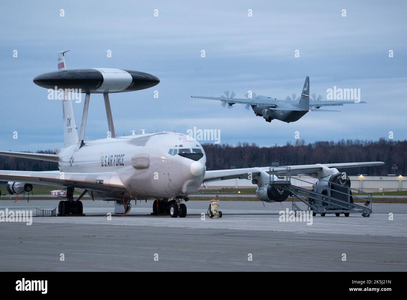 Un'aviazione militare statunitense C-130J Super Hercules assegnata alla 317th Airlift Wing presso la Dyess Air Force base, Texas, decoltra un'e-3 assegnata alla 552nd Air Control Wing presso la Tinker Air Force base, Oklahoma, durante LA BANDIERA ROSSA Alaska 23-1 presso la Joint base Elmendorf-Richardson, Alaska, 7 ottobre 2022. Questo esercizio offre opportunità uniche per integrare varie forze in formazione congiunta, di coalizione e multilaterale da basi operative simulate. (STATI UNITI Foto Air Force di Airman 1st Classe J. Michael Peña) Foto Stock