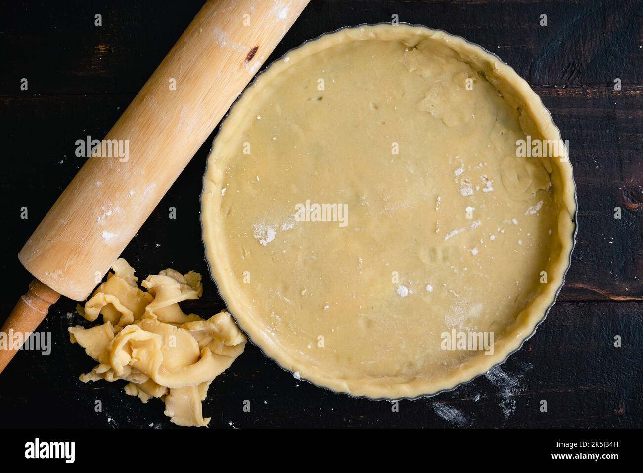 Teglia farcita con pasta cruda: Teglia farcita con sfridi di pasta sfoglia e un matterello Foto Stock