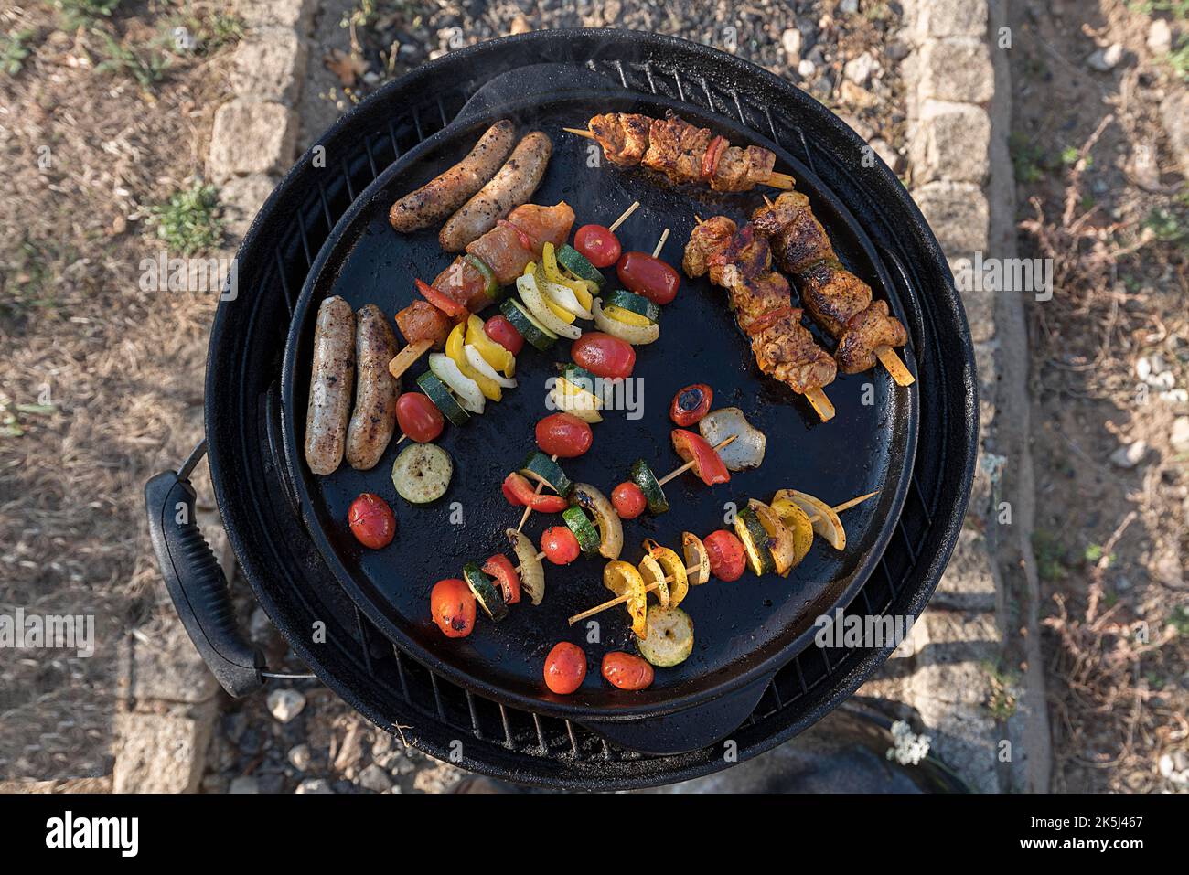 Bratwurst, spiedini di carne e verdure in una padella alla griglia, Baviera, Germania Foto Stock