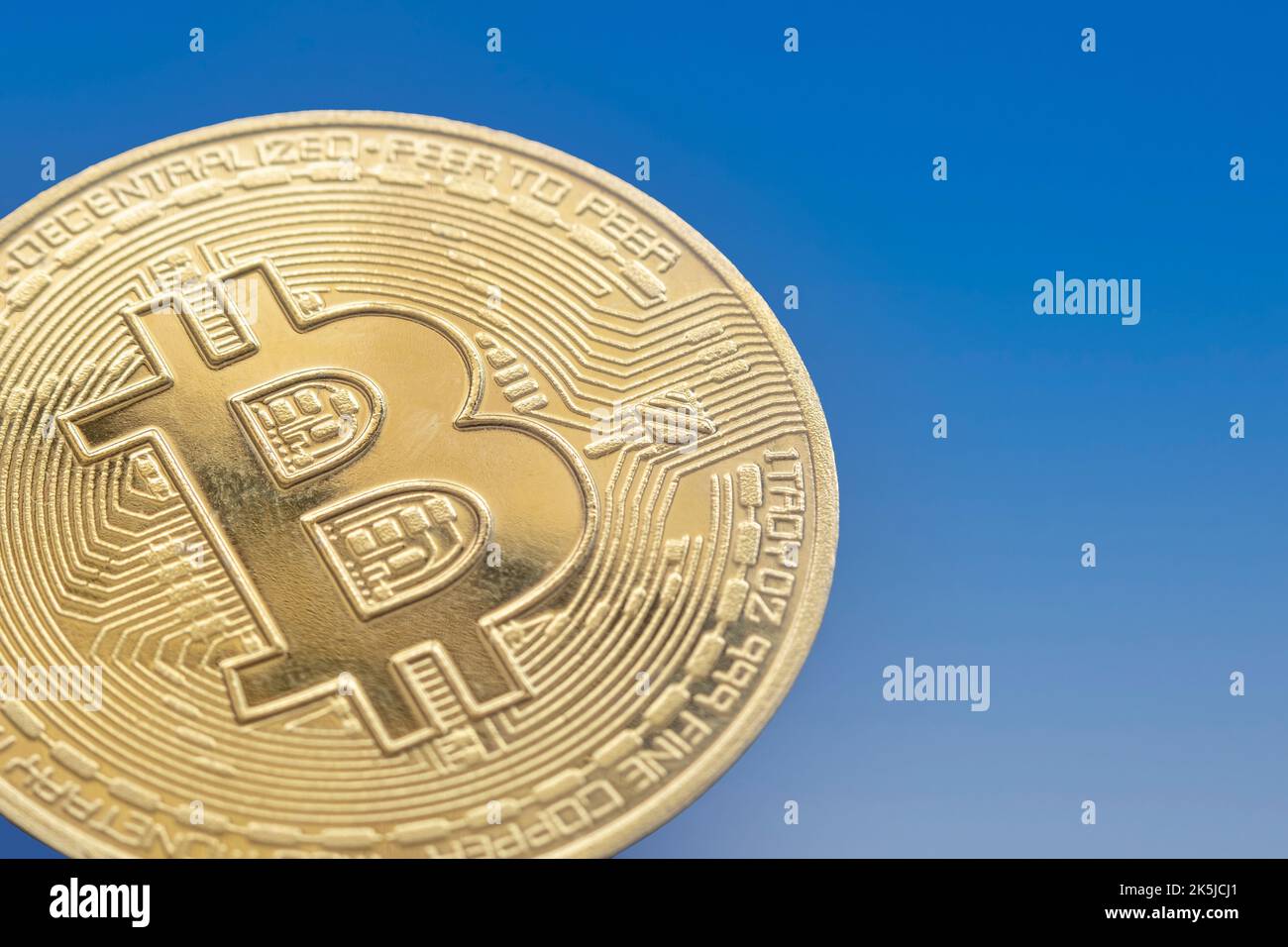 primo piano di una moneta di punta su uno sfondo blu sfumato, copia spazio Foto Stock