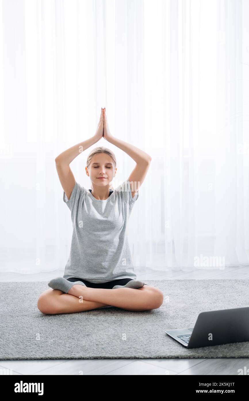 home yoga meditazione online rilassato ragazza laptop Foto Stock