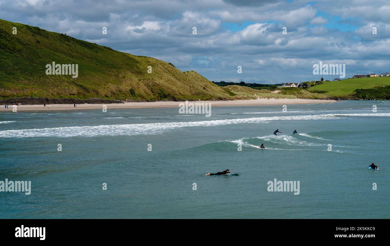 West Cork, Irlanda, 12 giugno 2022. I surfisti cavalcano le onde a Clonakilty in una bella giornata estiva. Sport acquatici in Irlanda, paesaggio. La costa irlandese di t Foto Stock