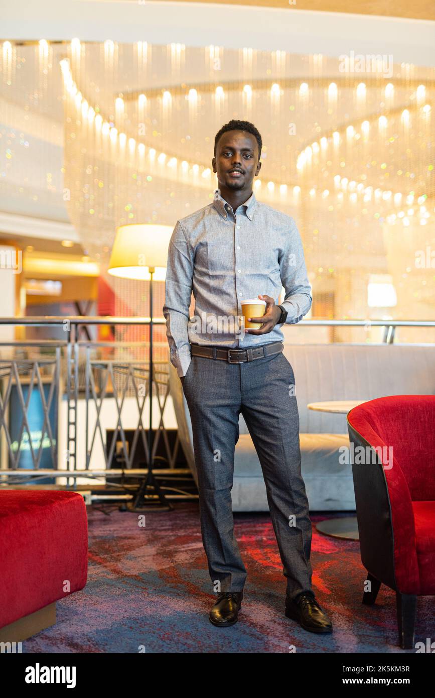 Ritratto di bel giovane africano che ha pausa caffè in piedi Foto Stock