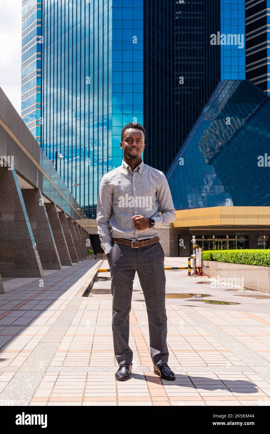 Ritratto di bel giovane africano all'aperto in città scatto a lunghezza intera Foto Stock