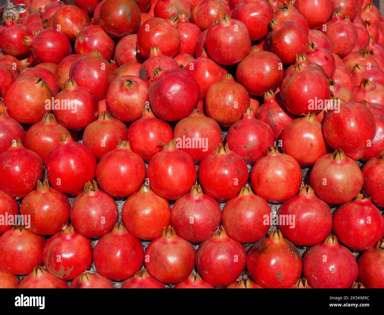 Mucchio di melograno. Cumulo di melograni maturi, pronti per la vendita sul mercato della frutta. Foto Stock