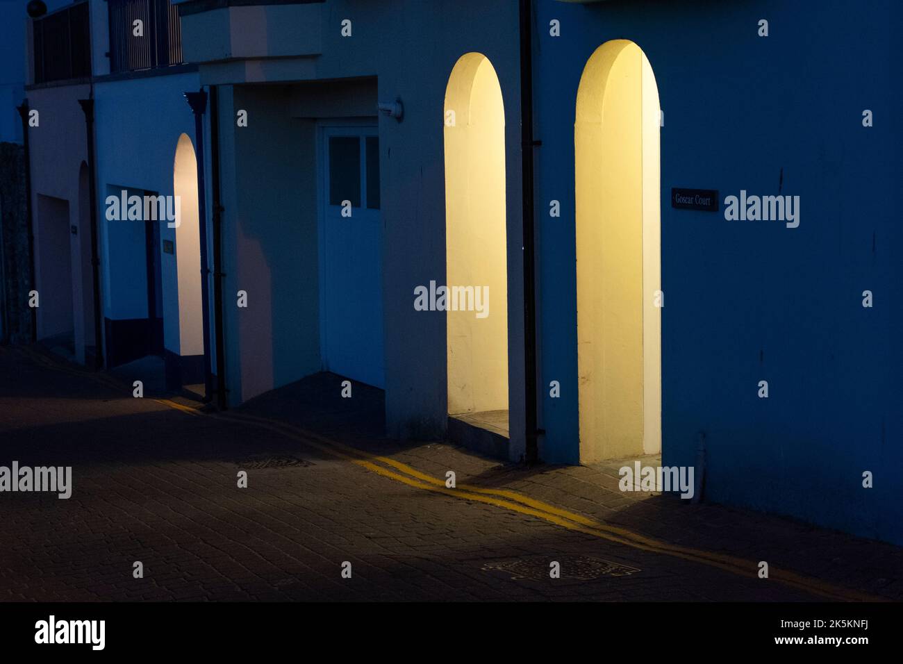 Tranquille strade di Tenby dopo l'orario di chiusura, illuminate dall'interno degli edifici. Tenby nel Galles occidentale Foto Stock