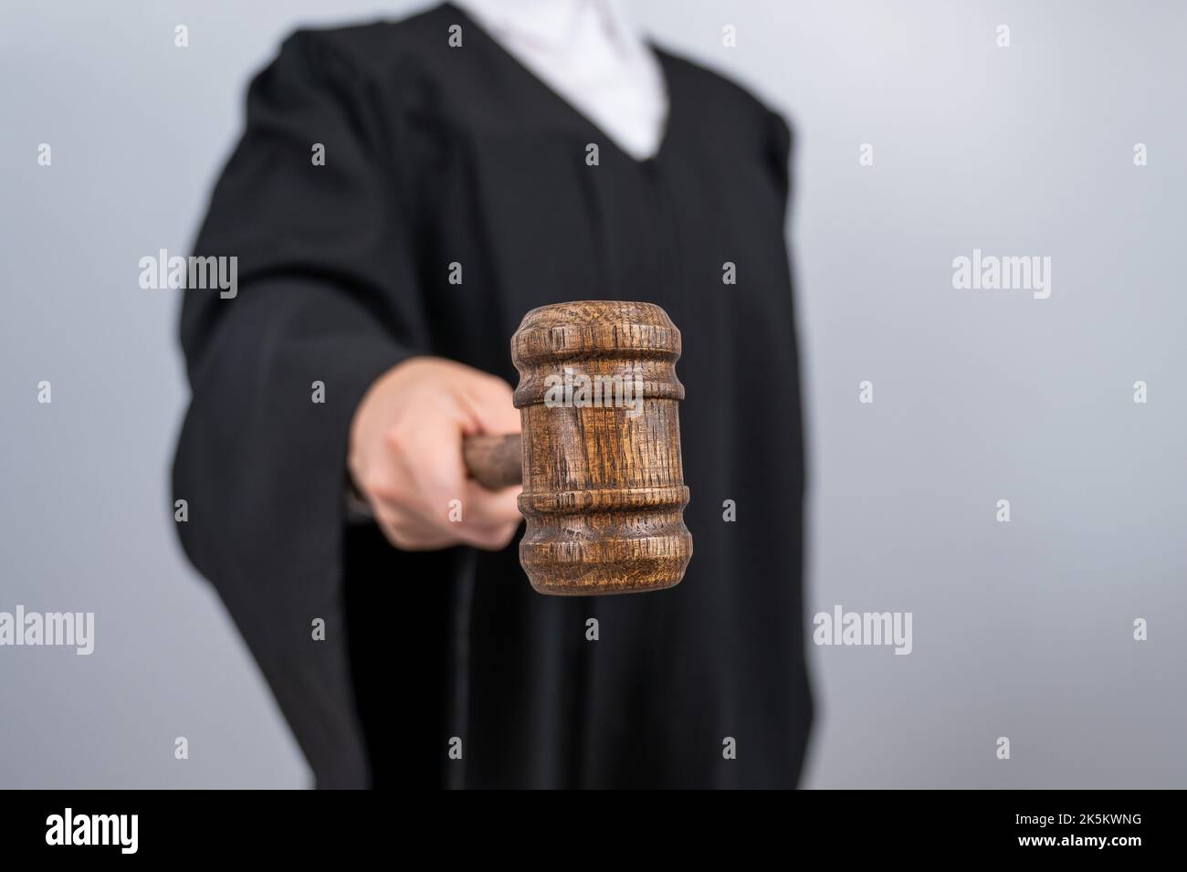 Giudice femminile senza volto in una vestiola che tiene un cavel di corte. Foto Stock