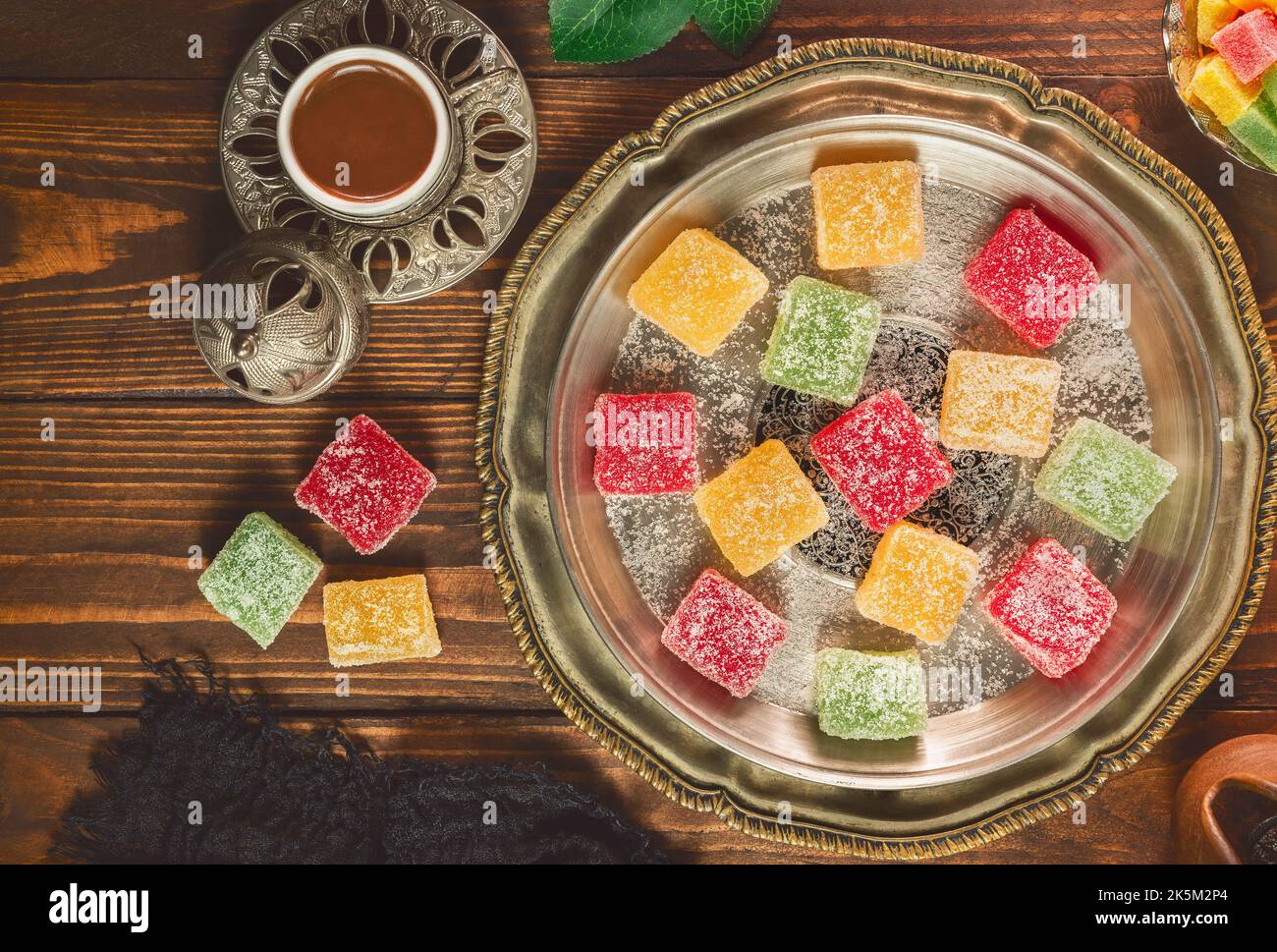 Tazza di caffè turca con chicchi di caffè tostati e delizie turche su sfondo rustico in legno. Vista dall'alto con spazio di copia. Foto Stock