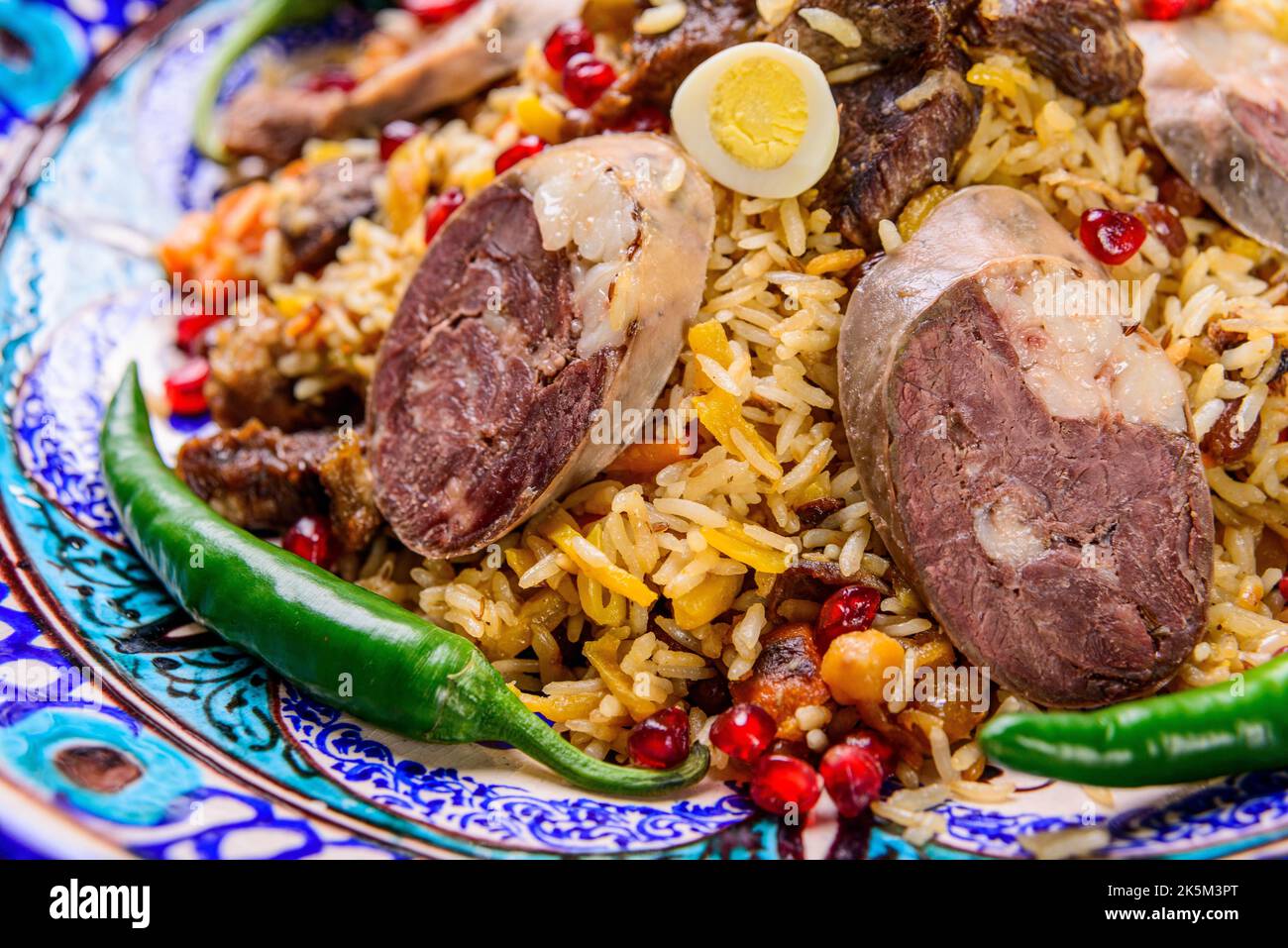 Un primo piano di un appetitoso piatto nazionale uzbeko plov, Pilaf a base di riso e carne servito con peperoni Foto Stock