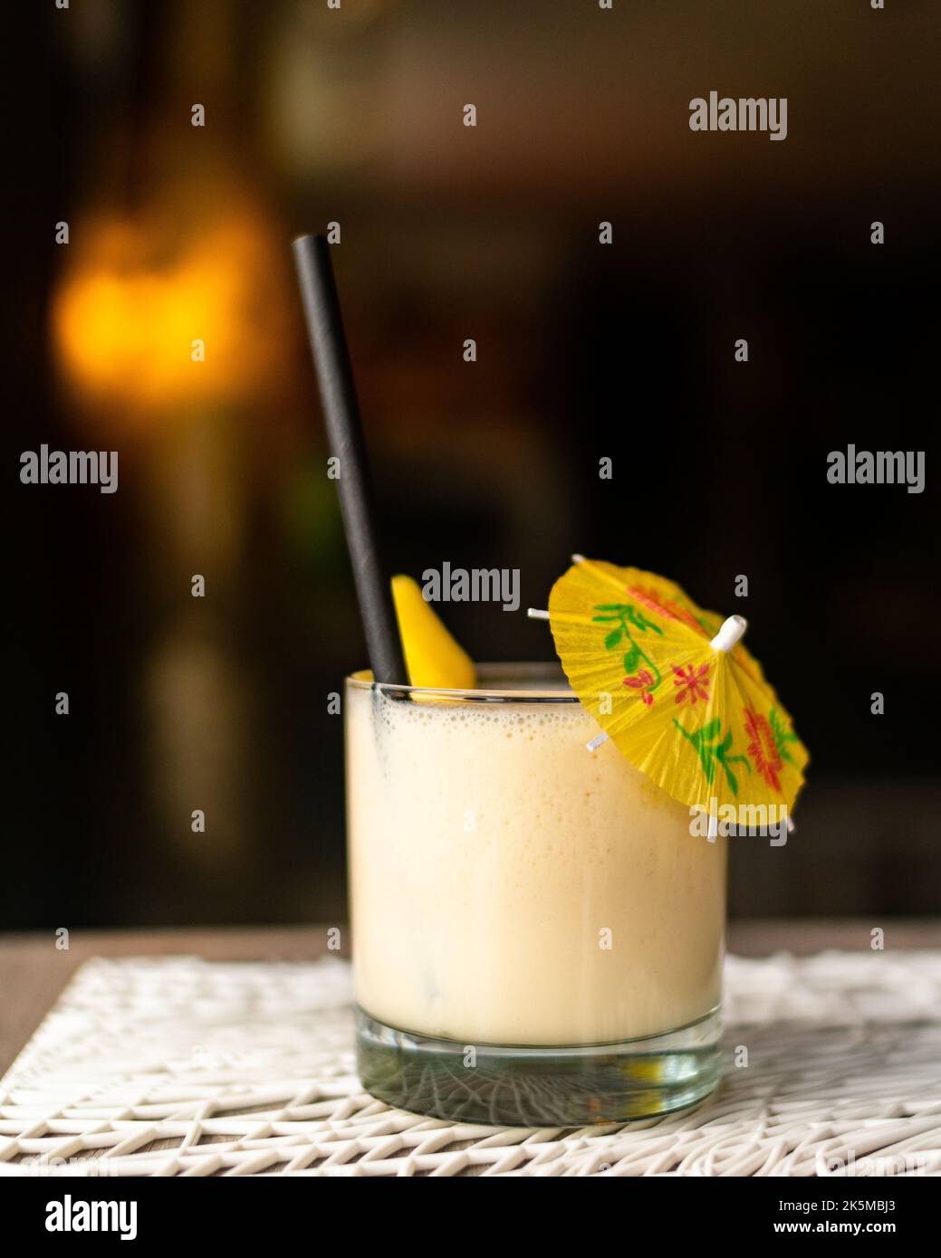 Un cocktail servito in un pub con un ombrellone Foto Stock