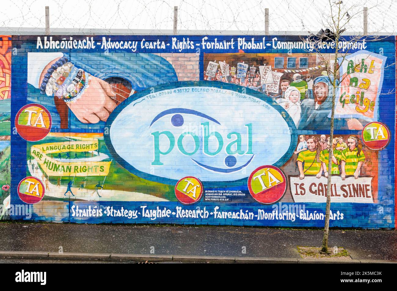 Il murale alla pace internazionale a parete, Belfast per Pobal, una lingua irlandese la carità Foto Stock