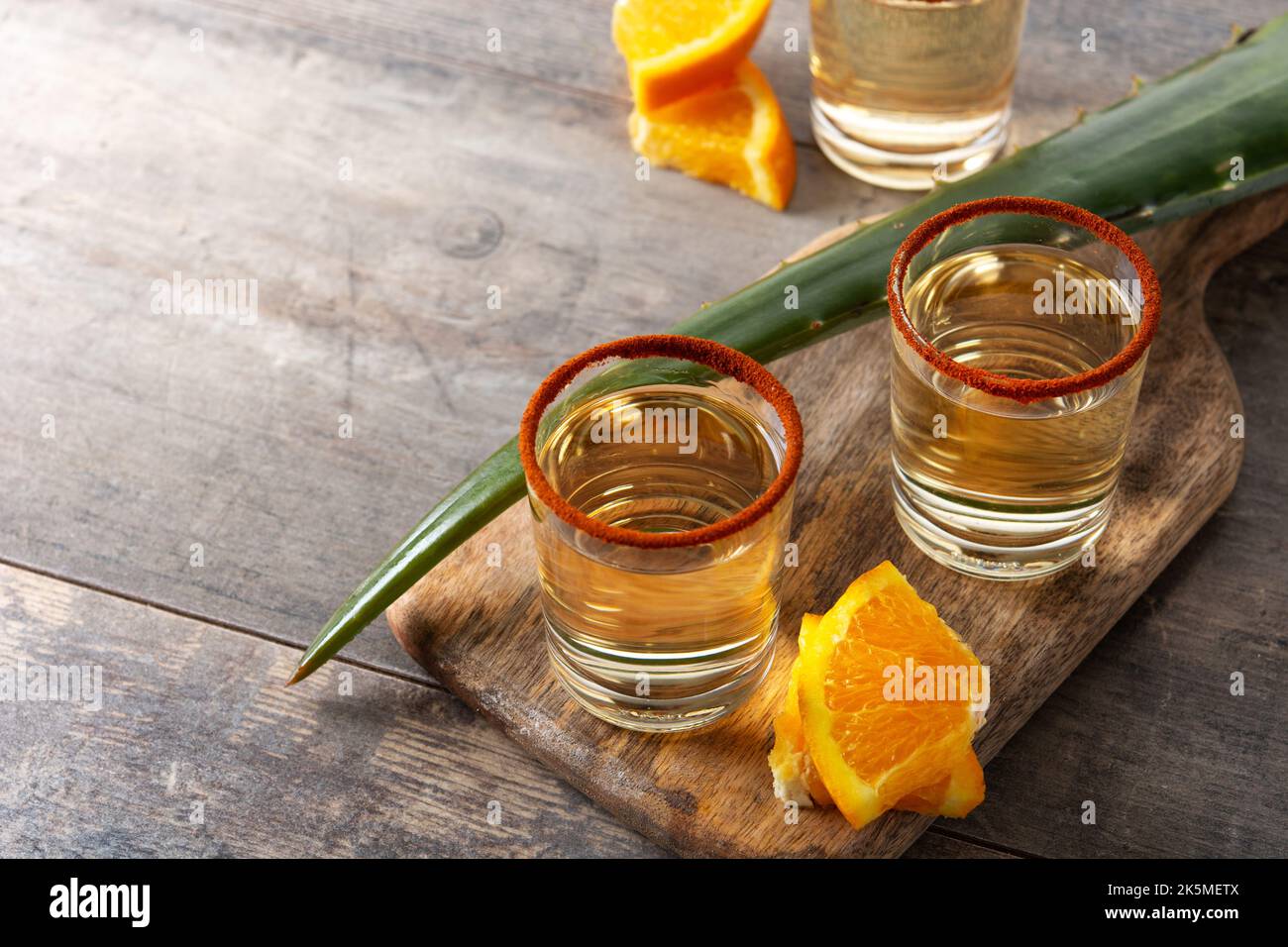 Mezcal bevanda messicana con fette d'arancia e sale di verme su tavola di legno Foto Stock