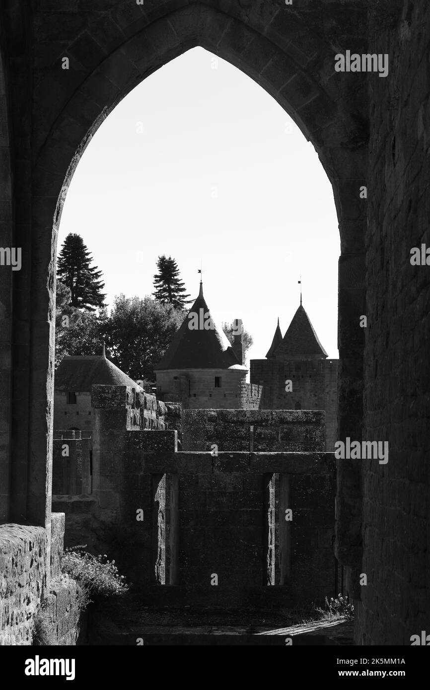 Vista della cittadella medievale di Carcassonne attraverso una porta ad arco. Le torri fortificate e le mura di pietra del sito patrimonio dell'umanità dell'UNESCO. Foto Stock