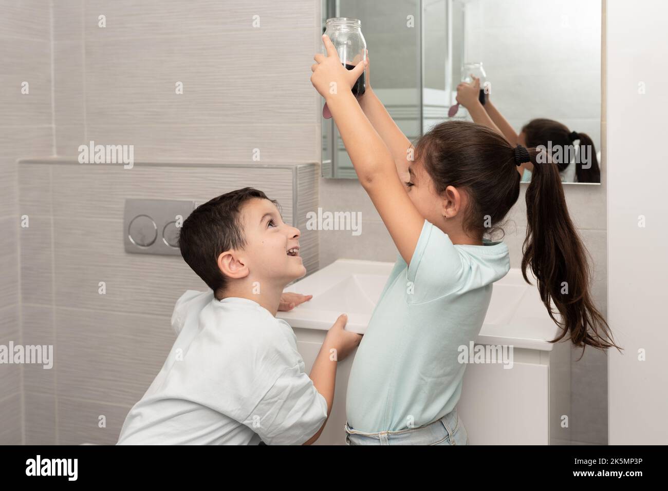 Bambini divertenti crescono cristalli, e guardare la soluzione di cristallizzazione in vaso di vetro . Foto Stock