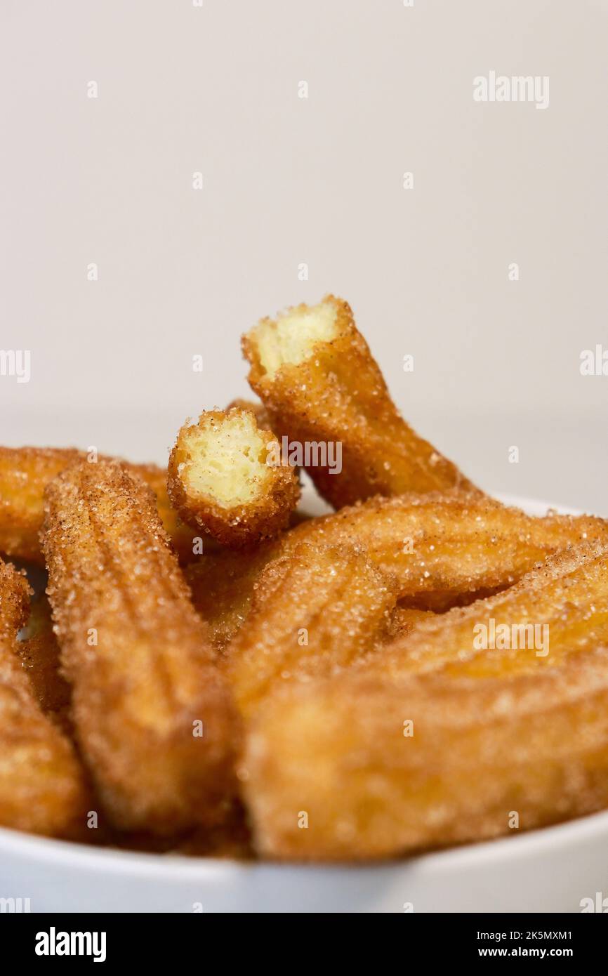 primo piano dei churros con lo zucchero nel recipiente bianco, vista dall'alto Foto Stock