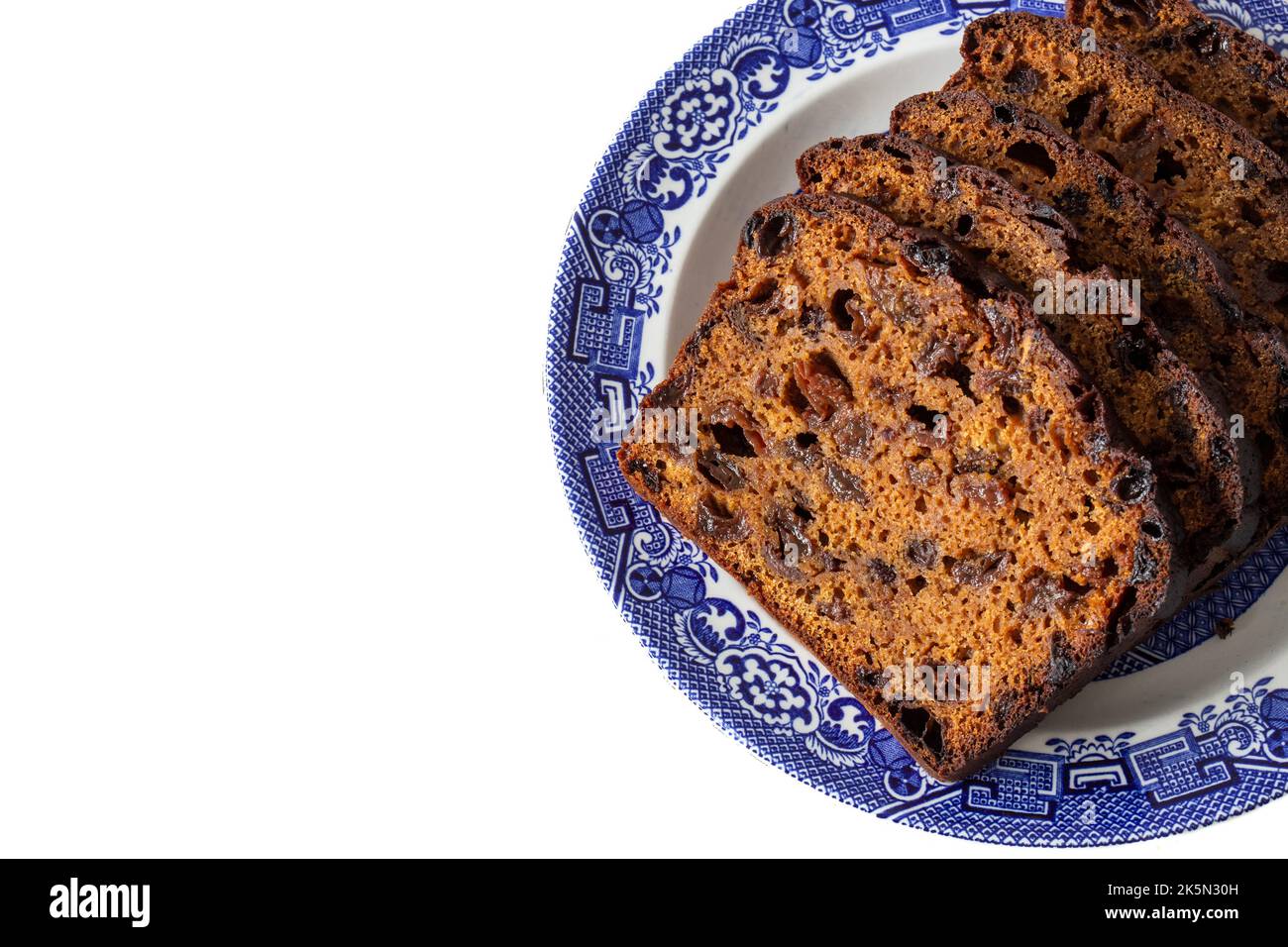 Torta di focaccia alla frutta tagliata su un piatto blu e bianco decorato. Su sfondo bianco Foto Stock