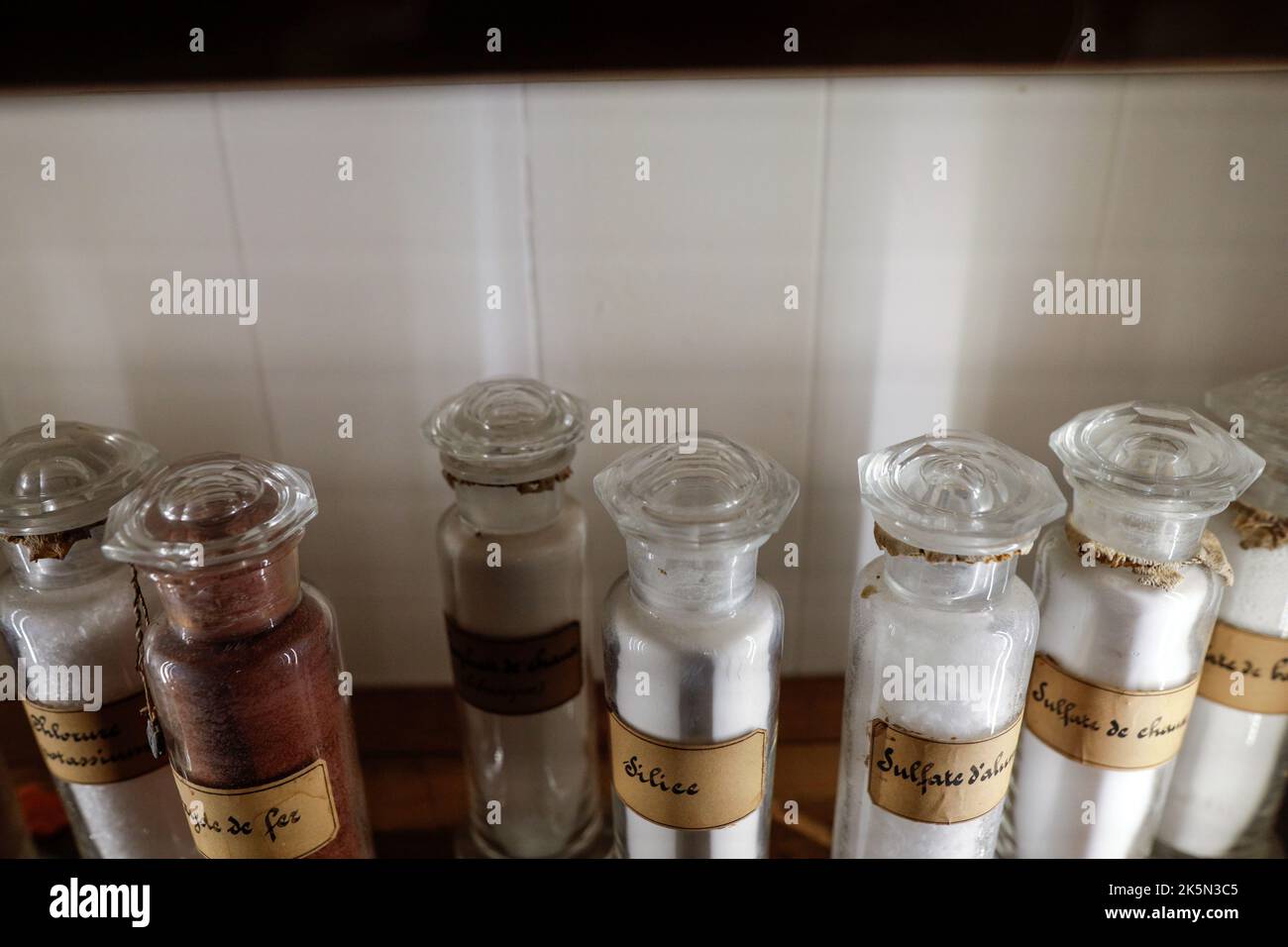 Profondità di campo bassa (fuoco selettivo) dettagli con varie fiale di vetro utilizzate per vecchi esperimenti chimici e medici all'interno di un museo. Foto Stock