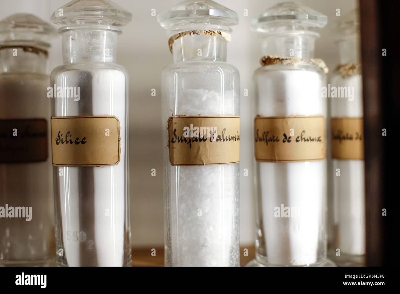 Profondità di campo bassa (fuoco selettivo) dettagli con varie fiale di vetro utilizzate per vecchi esperimenti chimici e medici all'interno di un museo. Foto Stock