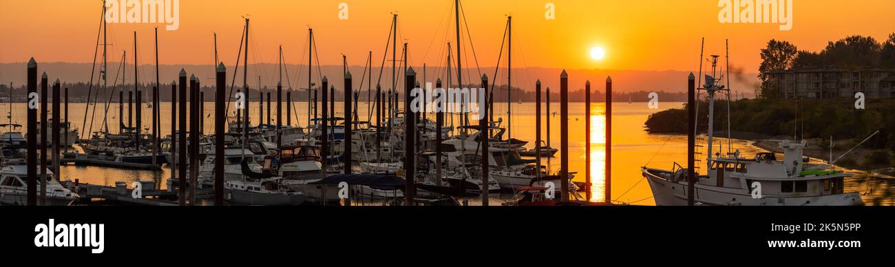 Paesaggio panoramico di un sole arancione che tramonta sul fiume Columbia e sul porticciolo delle barche, Vancouver, Washington Foto Stock