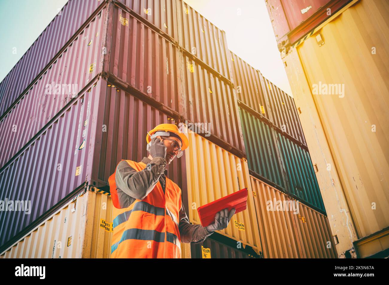 Il lavoratore comunica tramite radio per controllare i container di carico al carico del porto Foto Stock