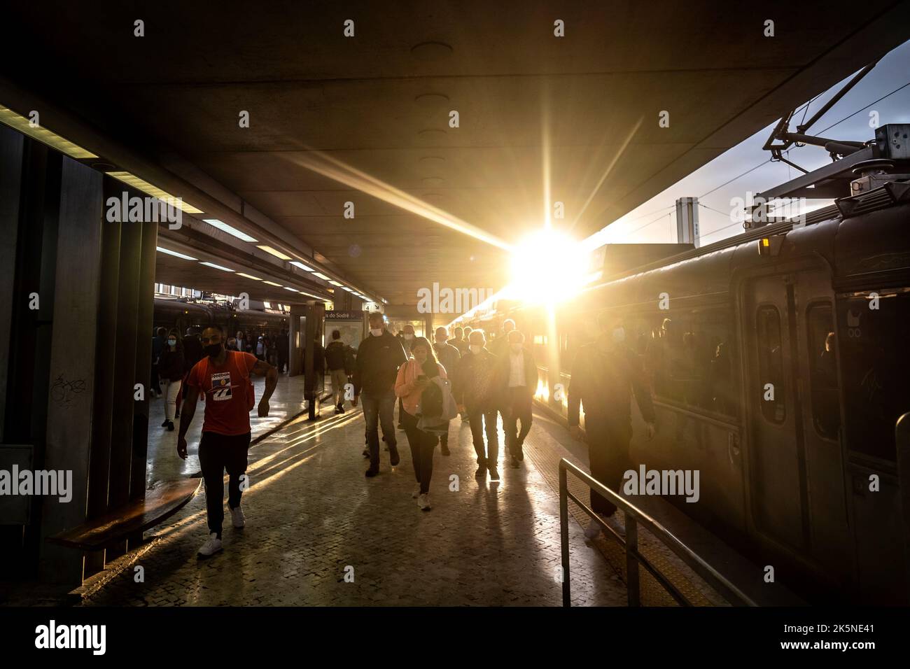 Cais do Sodré, Lisbona, Portogallo, pendolari sulla piattaforma ferroviaria al tramonto Foto Stock