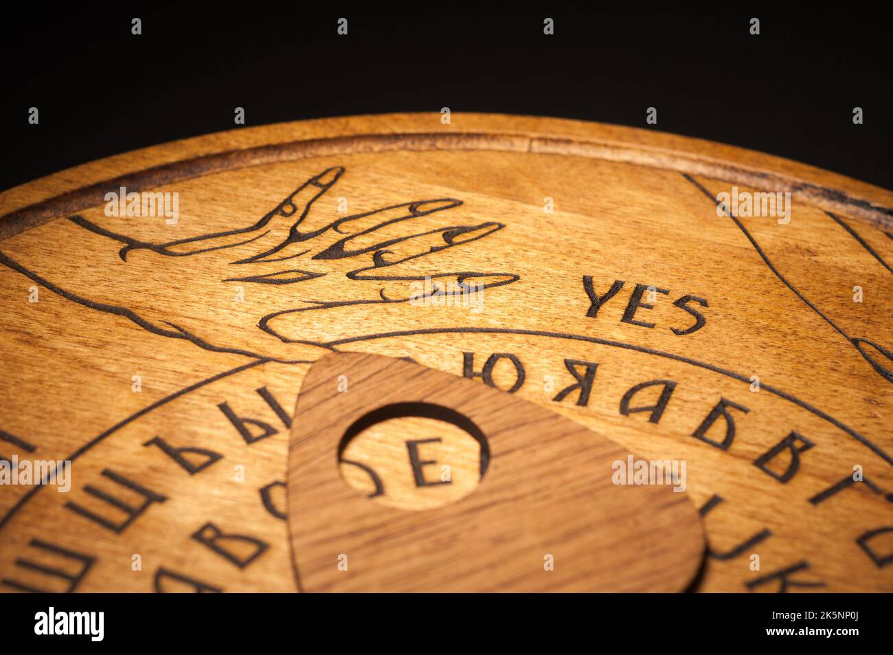 Un tavolo Ouija, giallo su sfondo nero Foto Stock