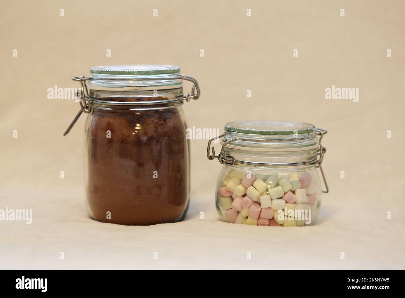 Regalo di Natale casalingo commestibile - vasetti di vetro ripieni di cacao in polvere speziato e mini marshmallows per cioccolata calda. Un regalo perfetto per il luogo! Foto Stock