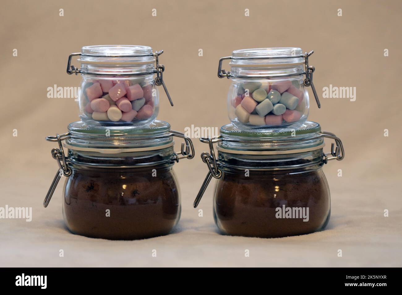 Regalo di Natale casalingo commestibile - vasetti di vetro ripieni di cacao in polvere speziato e mini marshmallows per cioccolata calda. Un regalo perfetto per il luogo! Foto Stock