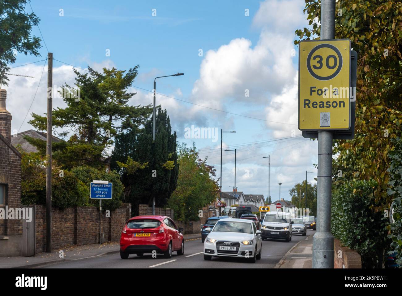 30 per un motivo di strada segno su una strada trafficata a Old Windsor, Berkshire, Inghilterra, Regno Unito. Segnaletica di sicurezza stradale Foto Stock