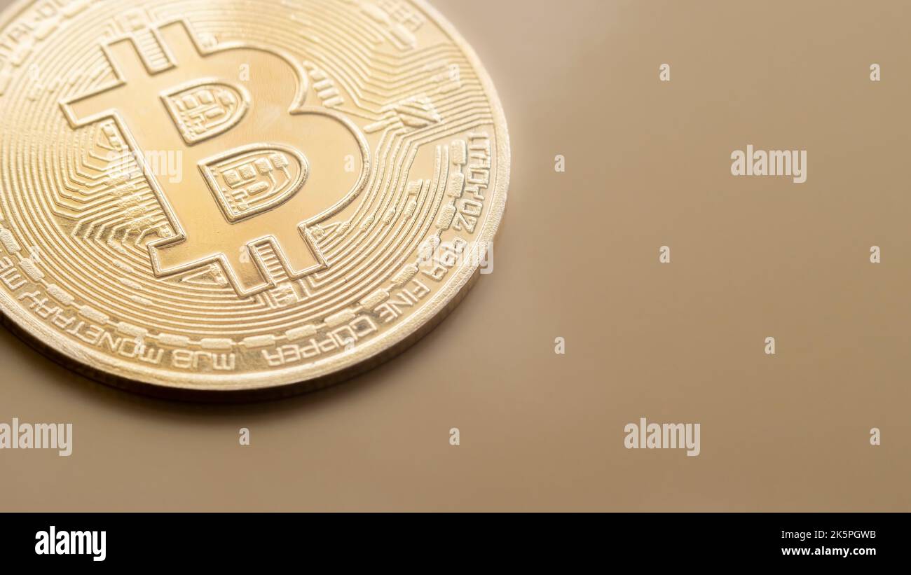 primo piano di un bitcoin crittoconico su fondo dorato, spazio copia, focus selettivo Foto Stock