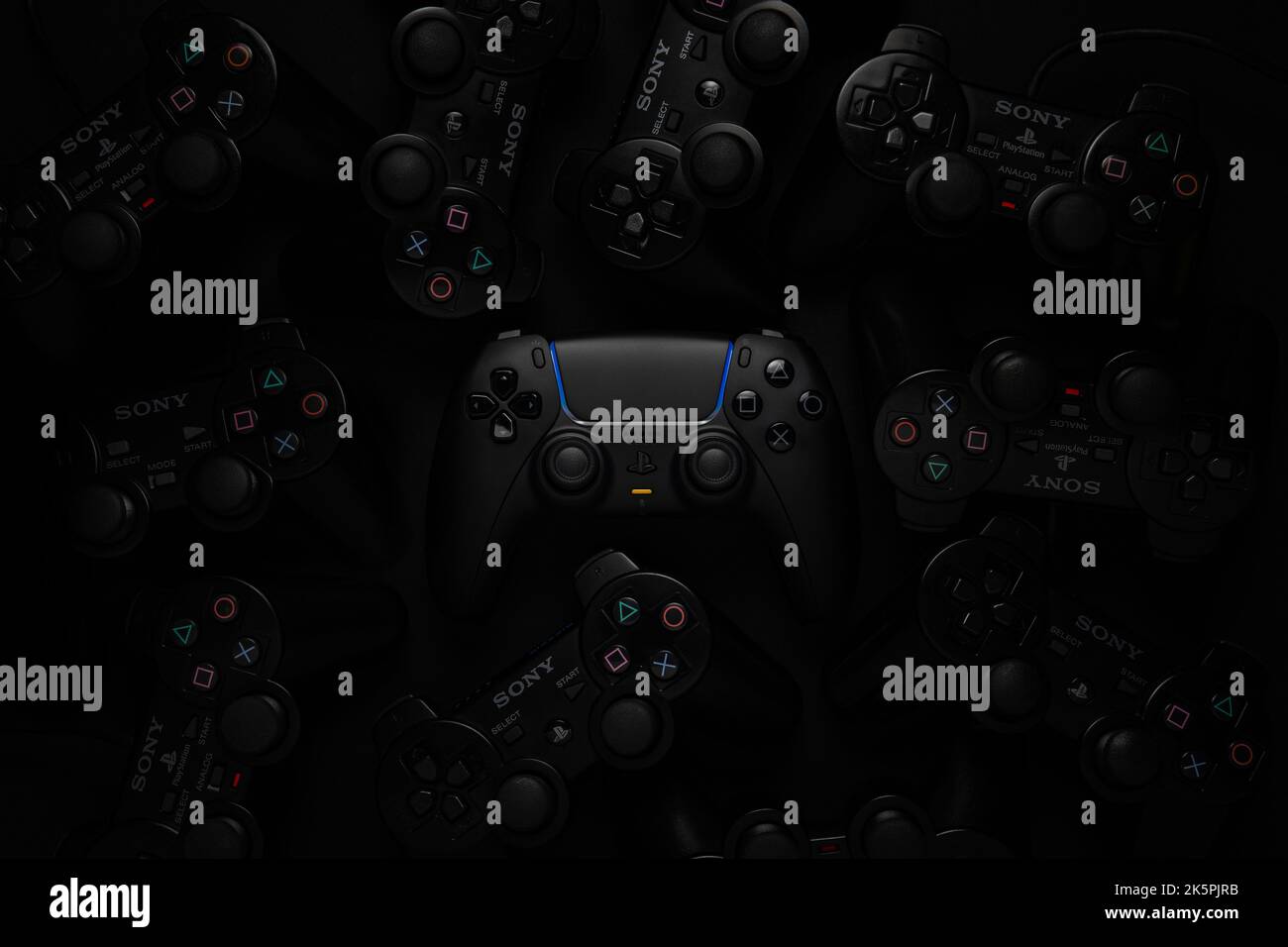 5 ottobre 2022, Odessa, Ucraina. Il nuovo dualsense nero del gamepad PlayStation 5 su uno sfondo scuro di diversi gamepad della famiglia playstation. CY Foto Stock