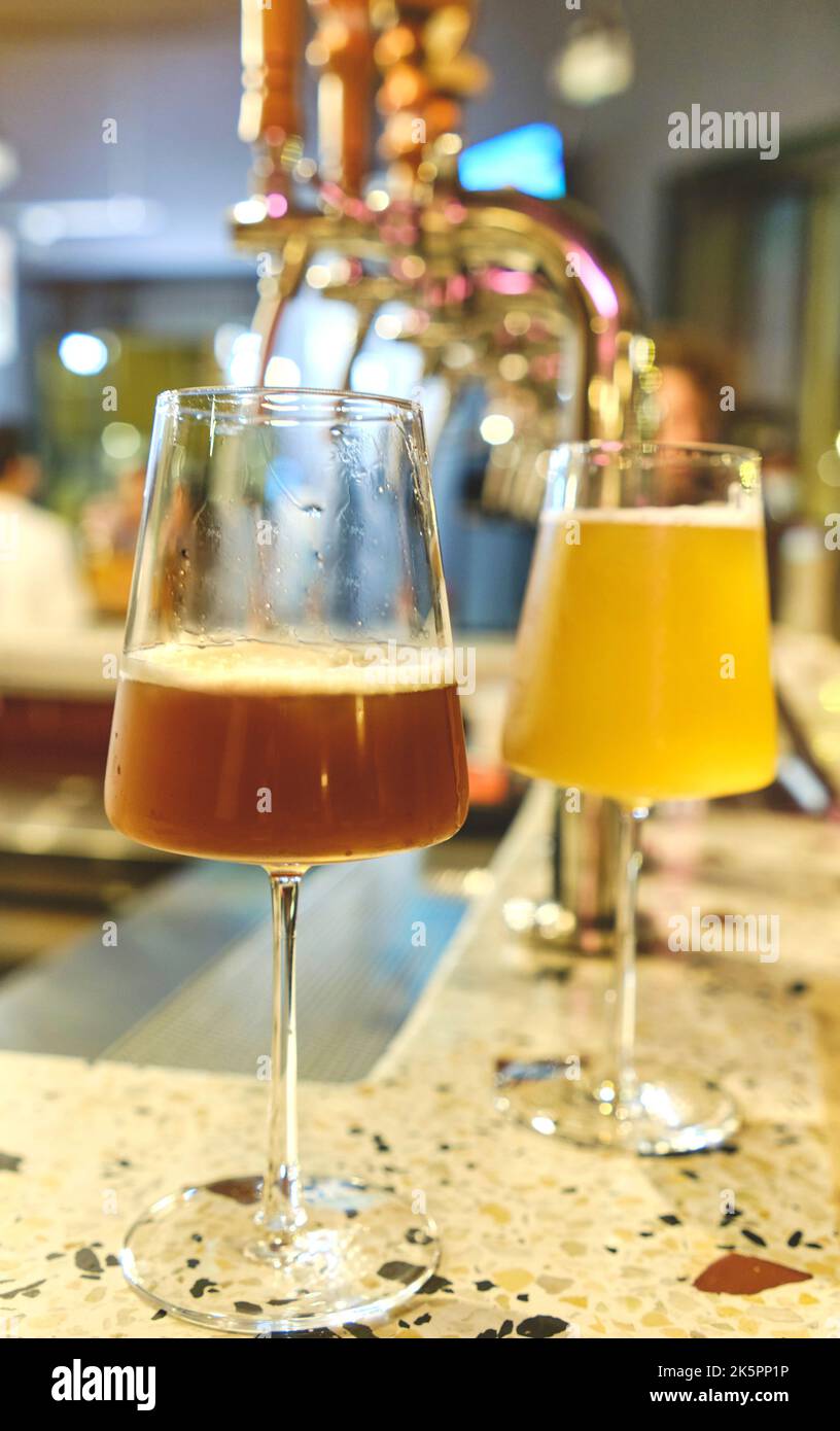Elegante bicchiere di birra artigianale e rubinetti. La birra si tap di fila in prospettiva. Messa a fuoco selettiva. Fine settimana Foto Stock