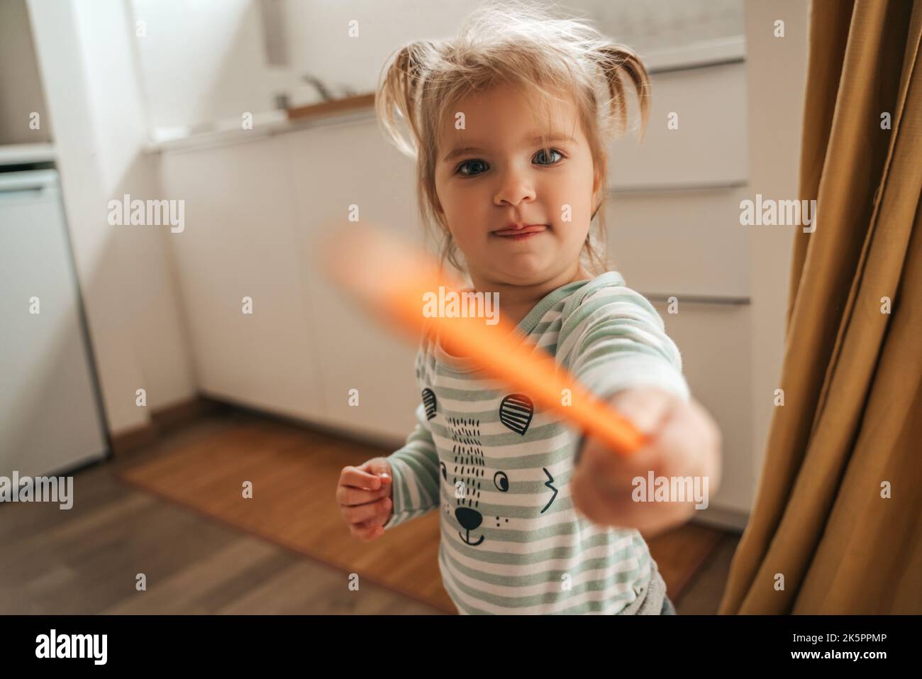 Femmina bambino maliziosa che gioca in cucina Foto Stock