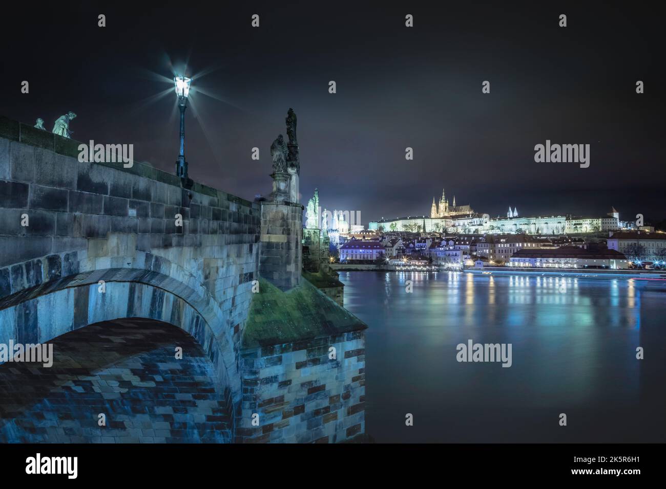 Ponte Carlo e il fiume Moldava di notte con movimento offuscato della barca, Praga Foto Stock