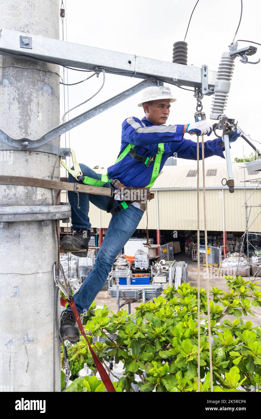 Un uomo di linea di una società elettrica che lavora su un polo elettrico a Cebu City, Filippine Foto Stock