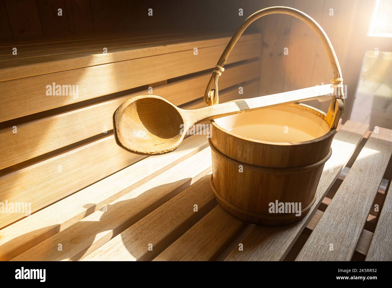 Cucchiaio in legno con secchio d'acqua per versare acqua su pietre calde nella sauna finlandese, spa e bagno termale a temperatura calda immagine concettuale. Sauna A. Foto Stock