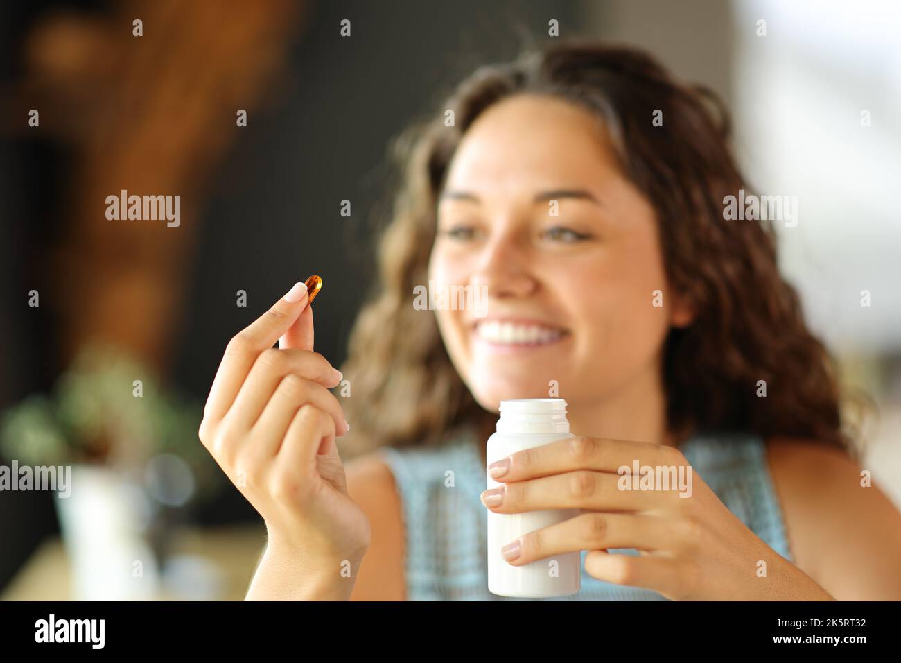 Donna felice pronta a mangiare una pillola di vitamina a casa o al ristorante Foto Stock