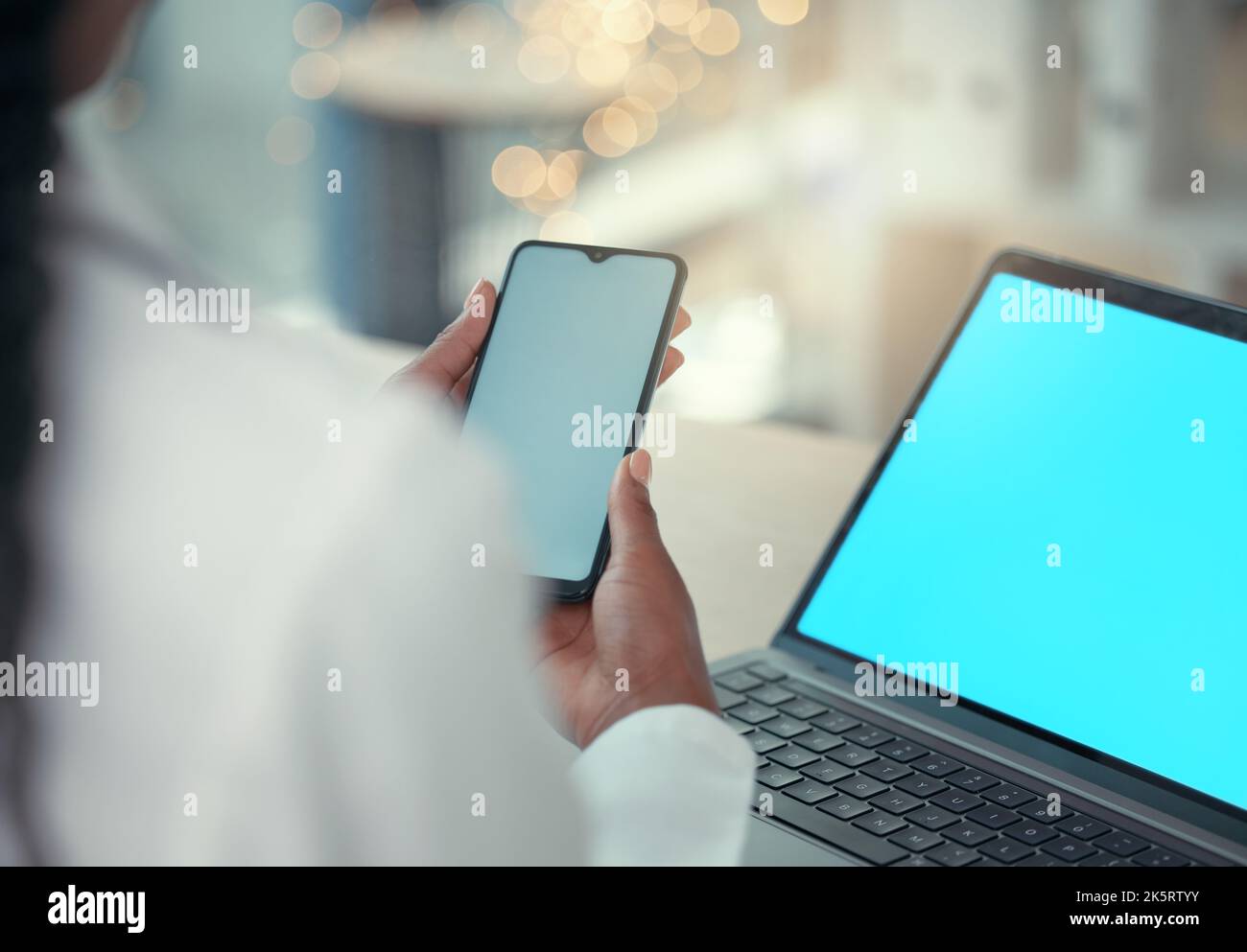 Medico che utilizza più dispositivi digitali al lavoro. Professionista medico che invia un testo su uno smartphone. Un operatore sanitario che naviga su un'app online su di lei Foto Stock