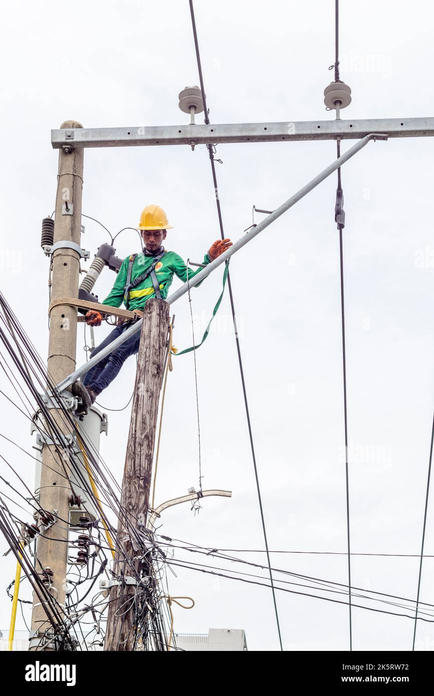 Un uomo di linea da una società di potere che ripristina il potere dopo Typhoon Odette a Cebu City, Filippine Foto Stock