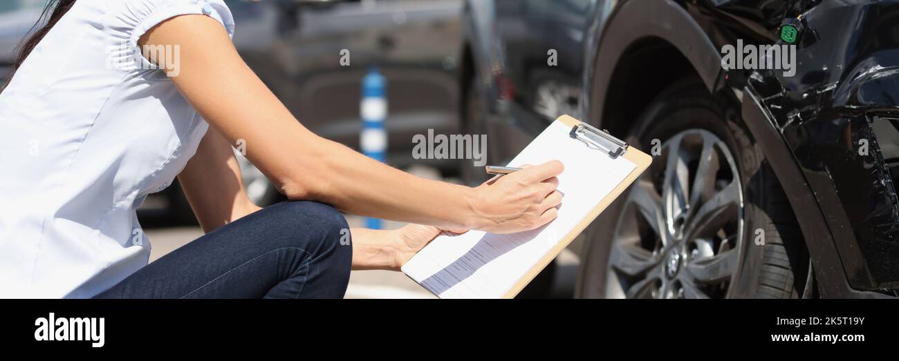 L'agente assicurativo registra i danni all'auto dopo l'incidente Foto Stock