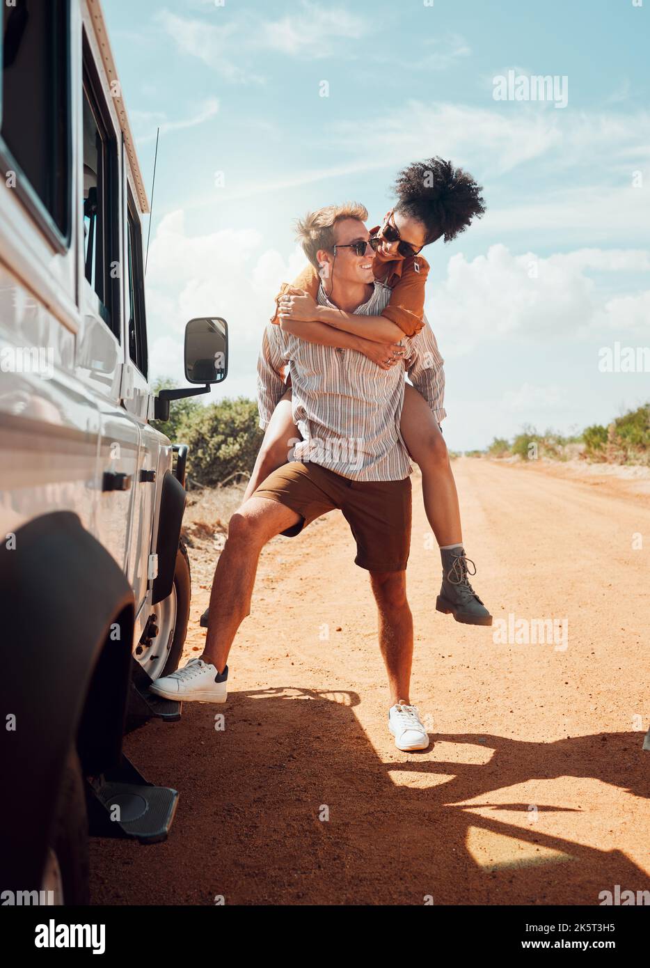 Viaggio, deserto e coppia abbracciare in viaggio su strada in Australia, ridere e divertirsi nella natura. Amore, libertà e felice donna e uomo essere sciocco, prendendo un Foto Stock