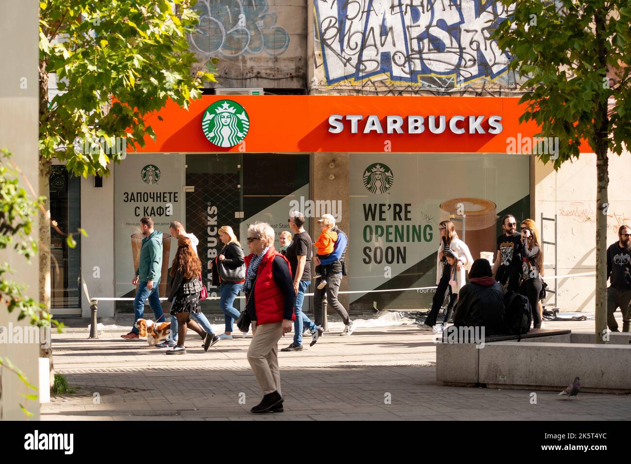 Persone che passeranno davanti a una nuova caffetteria Starbucks in costruzione e presto apriranno a Piazza Slaveykov a Sofia, Bulgaria, Europa orientale, Balcani Foto Stock