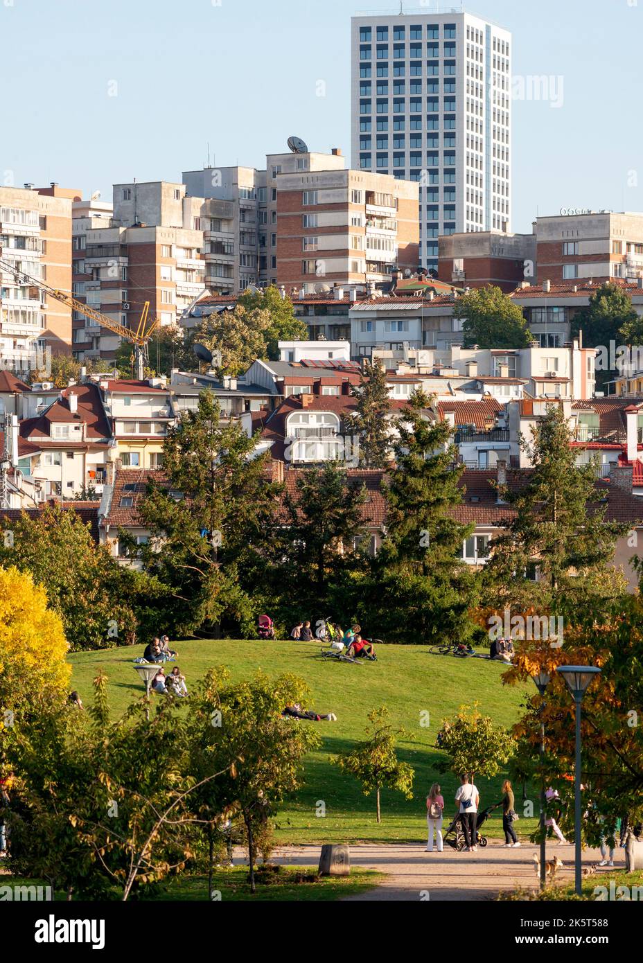 Scena urbana con persone a South Park con vista su edifici residenziali su una collina nel centro di Sofia, Bulgaria, Europa orientale, Balcani, UE Foto Stock