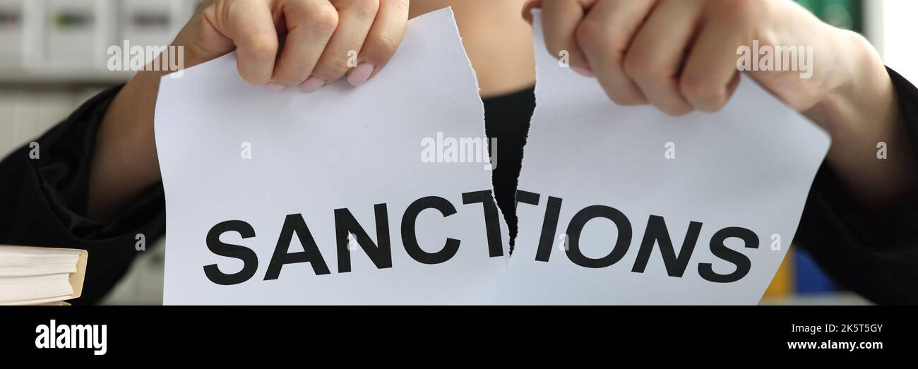 Leader mani strappare il documento con iscrizione sanzioni primo piano Foto Stock