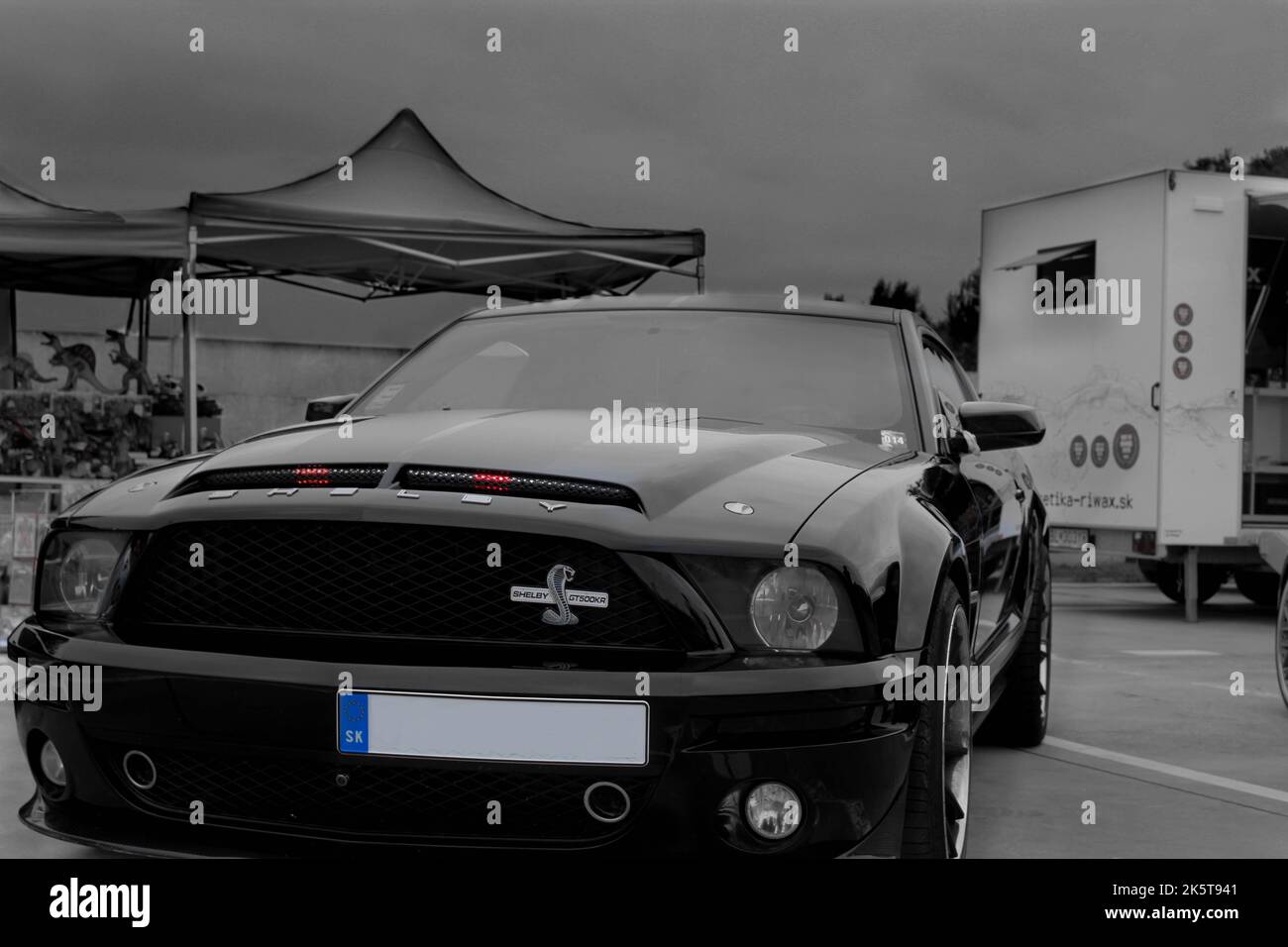 Una scala di grigi verticale di un Shelby Mustang parcheggiato all'aperto Foto Stock