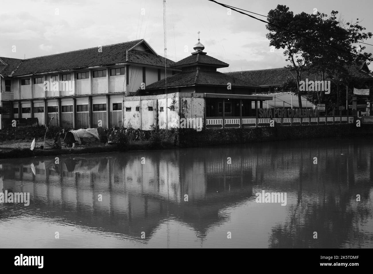 Riflessione dell'edificio, foto monocromatica del riflesso dell'ombra della moschea nello stagno nella zona di Cikancung - Indonesia Foto Stock