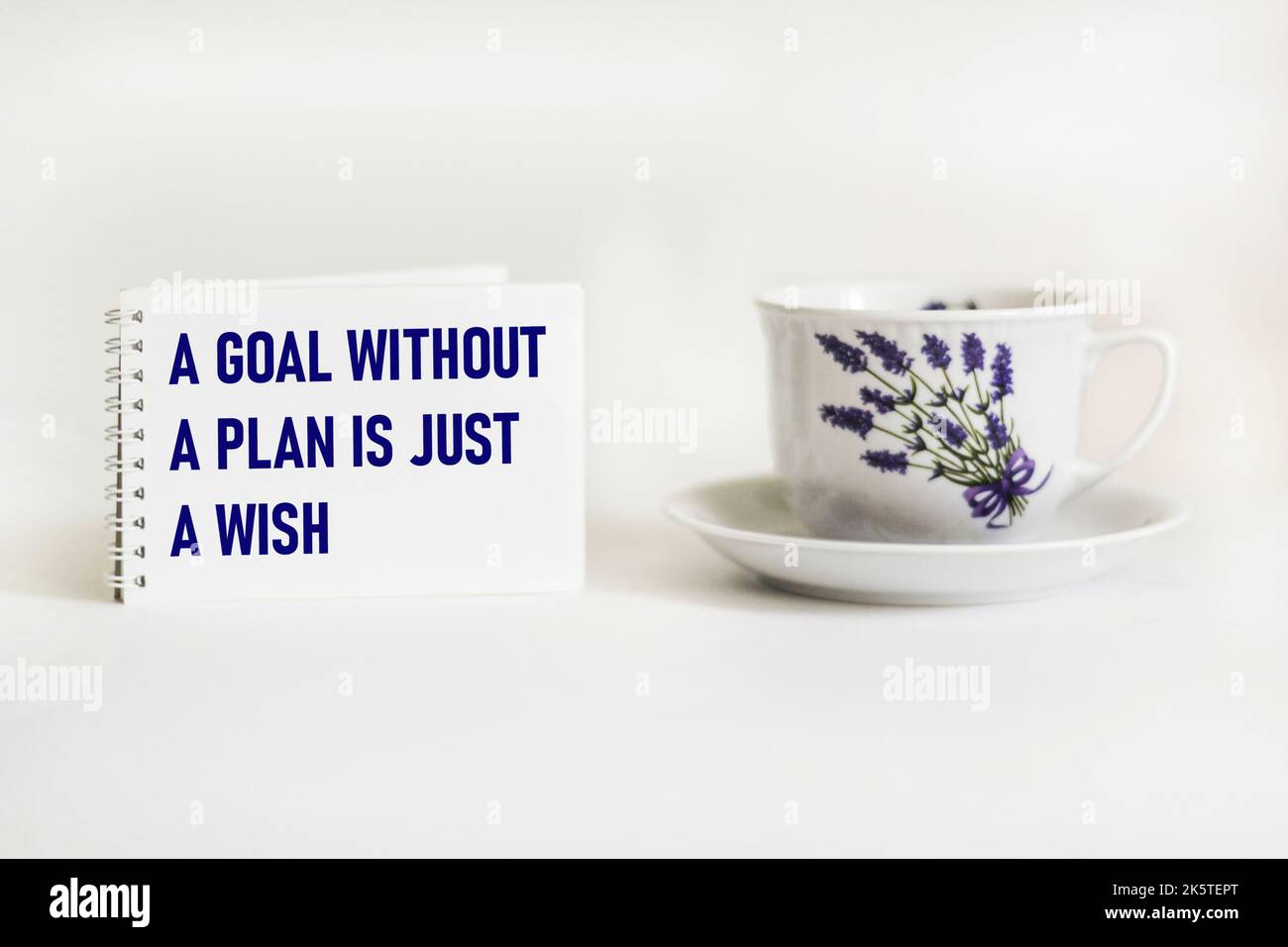 Un obiettivo senza un piano è solo un desiderio - testo su un blocco note con una penna e una tazza di caffè su uno sfondo bianco Foto Stock