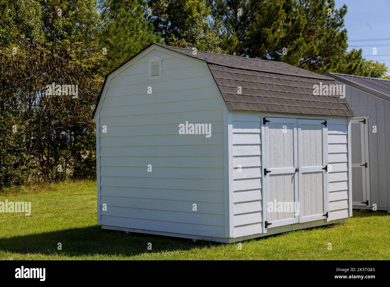 Capannone di stoccaggio in legno per attrezzi da giardinaggio nel cortile Foto Stock