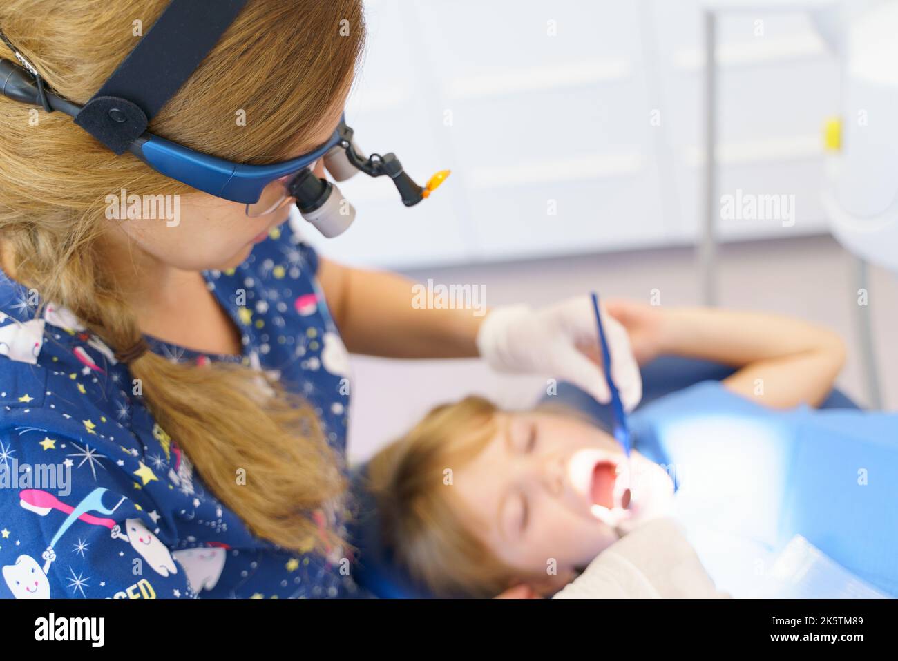 Giovane donna dentista facendo esame preventivo bambina. Foto Stock